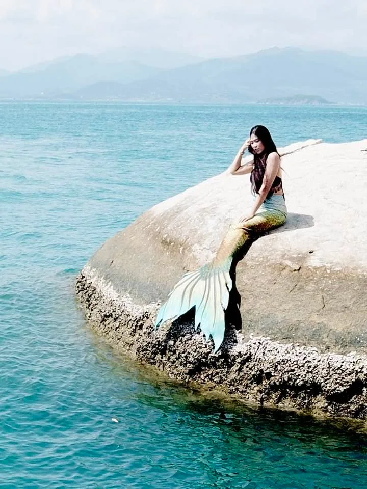 Vy Đan hóa nàng tiên cá ngồi trên tảng đá giữa biển xanh