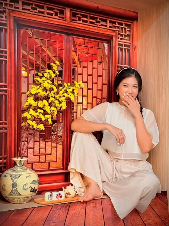 Vy Đan trước khung cửa son thếp vàng