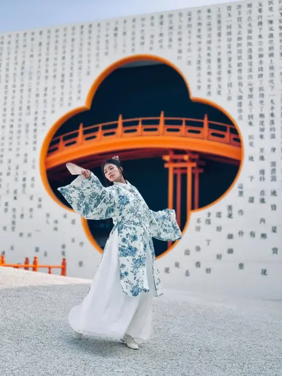 Vy Đan áo men lam dưới cổng hình mây