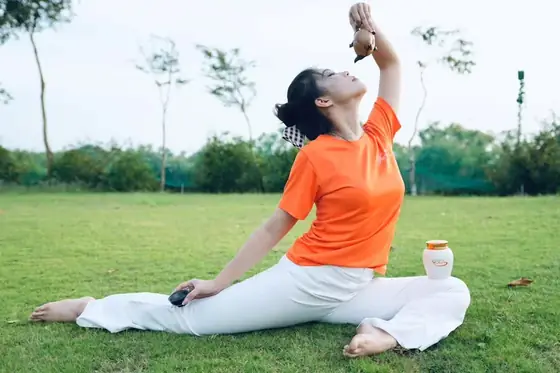 Tư thế yoga ngoài bãi cỏ cùng chén trà